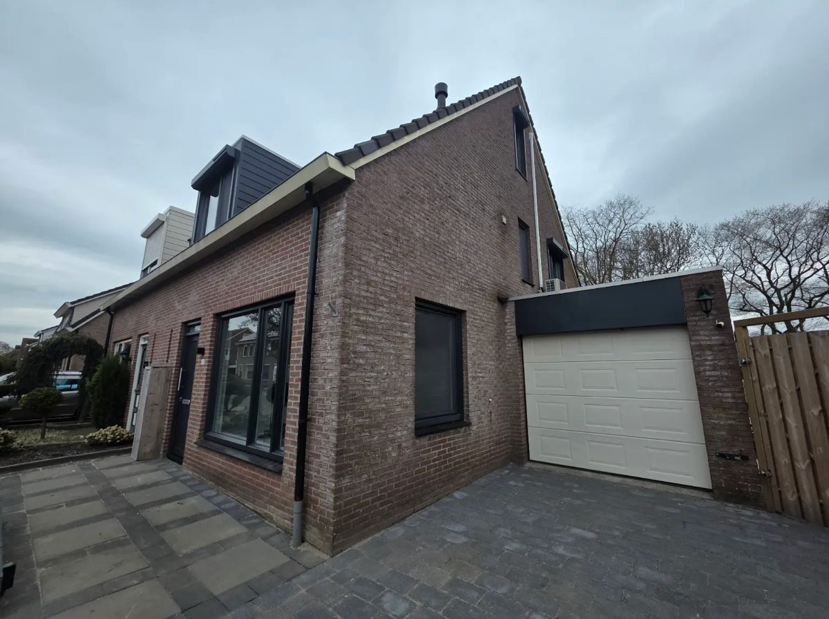 Woning met nieuwe zwarte kozijnen en aangebouwde garage